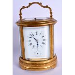 A LARGE ANTIQUE FRENCH OVAL REPEATING BRASS CARRIAGE CLOCK decorated with foliage. 21 cm high inc h