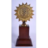 AN ANTIQUE BRONZE MASONIC STANDARD upon a mahogany base. 33 cm high.