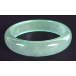 A CHINESE CARVED JADEITE BANGLE 20th Century. 7.25 cm wide.