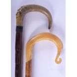 A 19TH CENTURY CARVED RHINOCEROS HORN WALKING CANE together with another. 88 cm long. (2)