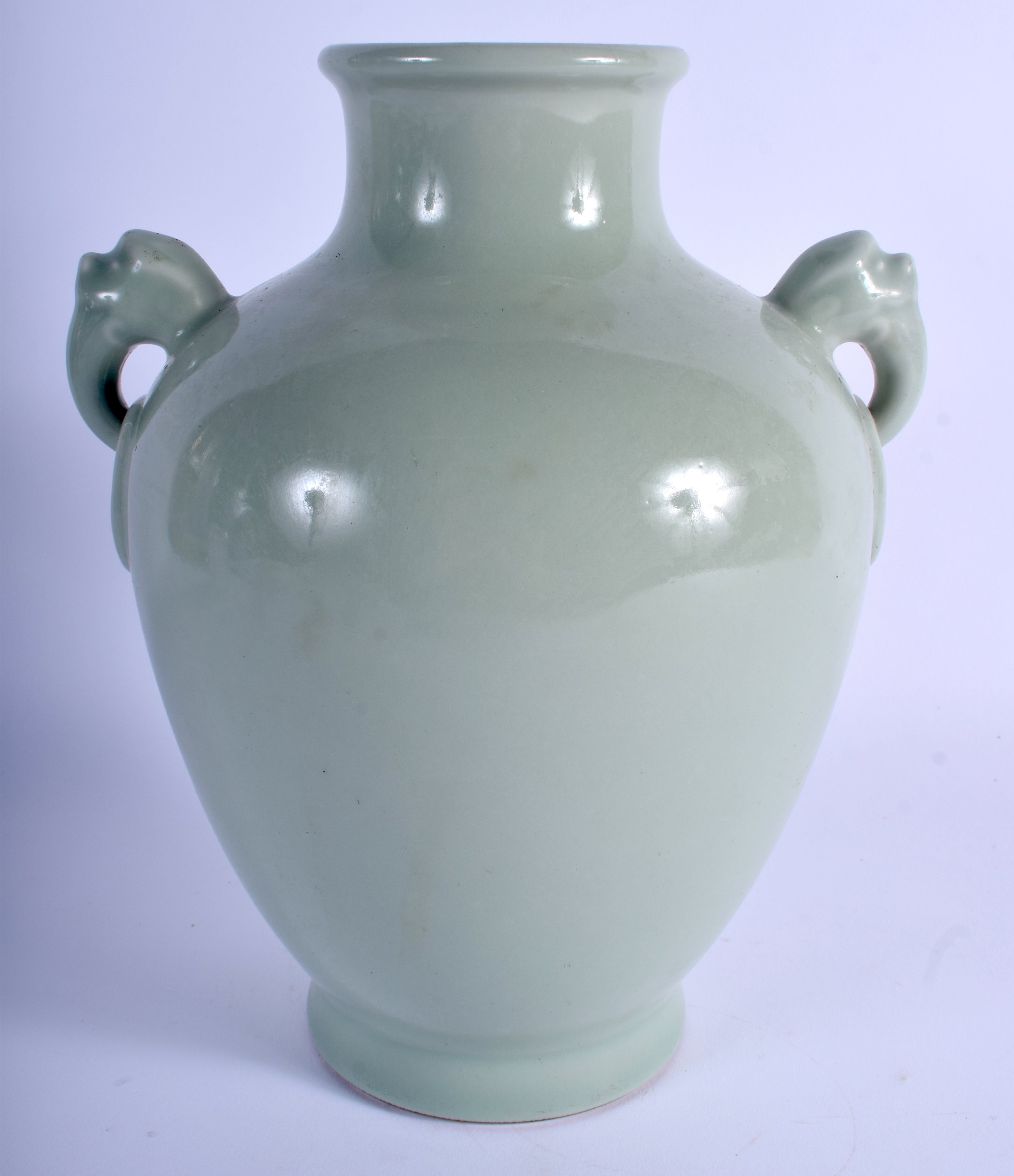 A CHINESE CELADON TWIN HANDLED PORCELAIN VASE bearing Qianlong marks to base. 24 cm x 14 cm.