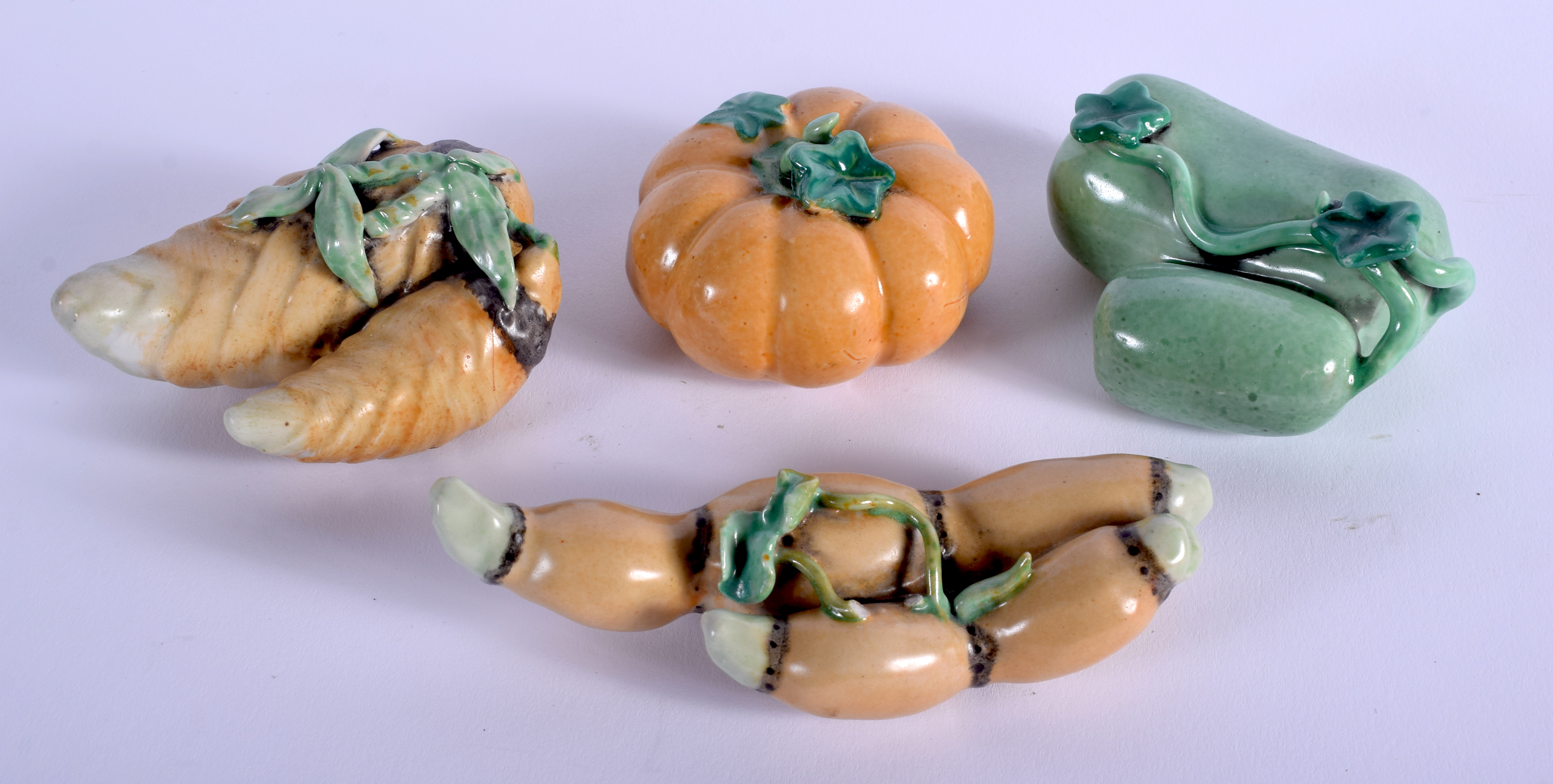 FOUR EARLY 20TH CENTURY CHINESE PORCELAIN SCROLL WEIGHTS Late Qing, in the form of fruits. Largest