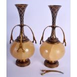 A PAIR OF 19TH CENTURY FRENCH CHAMPLEVE ENAMEL AND ONYX VASES in the manner of Barbedienne. 25 cm h