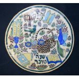 A Jewish round glazed tile decorated with flowers ,birds and scrolls 26cm