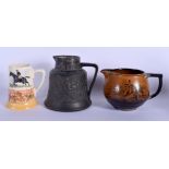 AN ARTS AND CRAFTS BASALT S & S SILVER MOUNTED JUG together with two other jugs. Largest 19 cm x 15