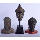 THREE SOUTH EAST ASIAN BRONZE BUDDHA HEADS in various forms and sizes. Largest 26 cm high overall.