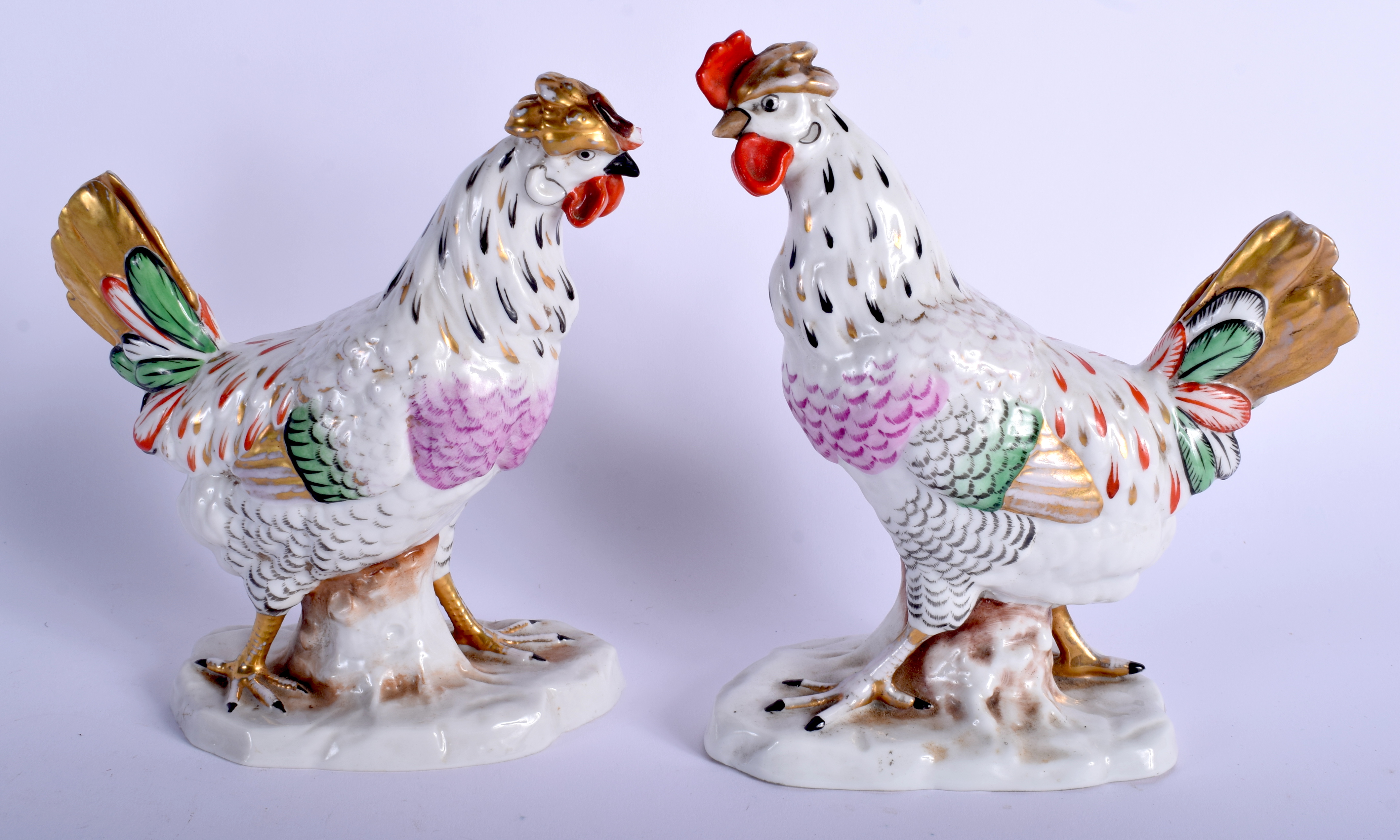 A PAIR OF EARLY 20TH CENTURY GERMAN PORCELAIN BIRDS modelled upon a naturalistic base. 17 cm x 10 c