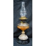 A Victorian Oil Lamp on a brass column mounted on a glass base brown glass reservoir 51cm