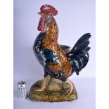 A LARGE 19TH CENTURY CONTINENTAL MAJOLICA FIGURE OF A ROAMING COCK modelled upon a naturalistic bas