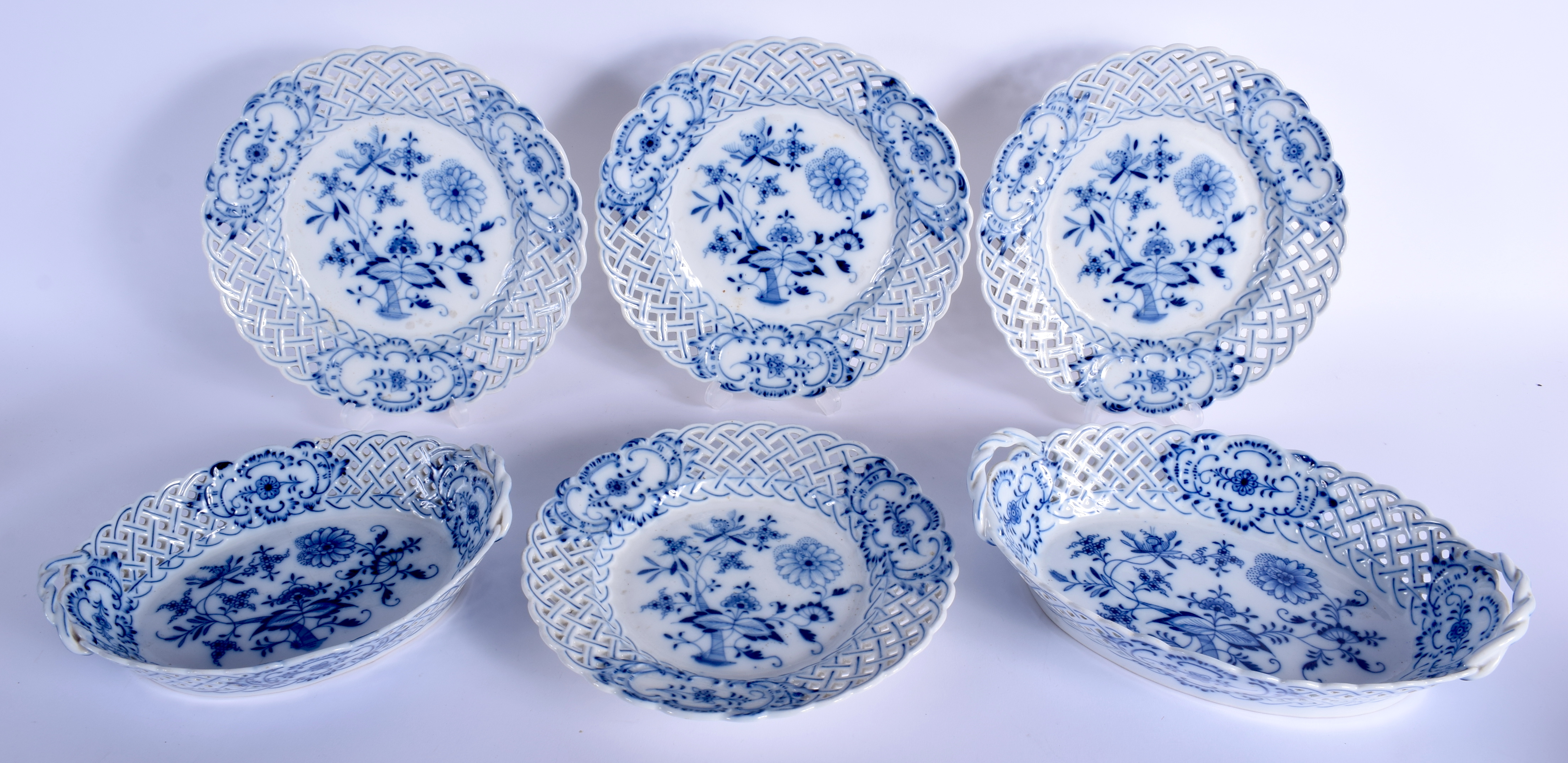 FOUR MEISSEN BLUE AND WHITE PLATES together with two baskets. Largest 29 cm wide. (6)