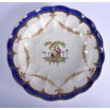 Worcester deep dish painted with a bird in landscape under gilt swags and a blue border. 23Cm diame