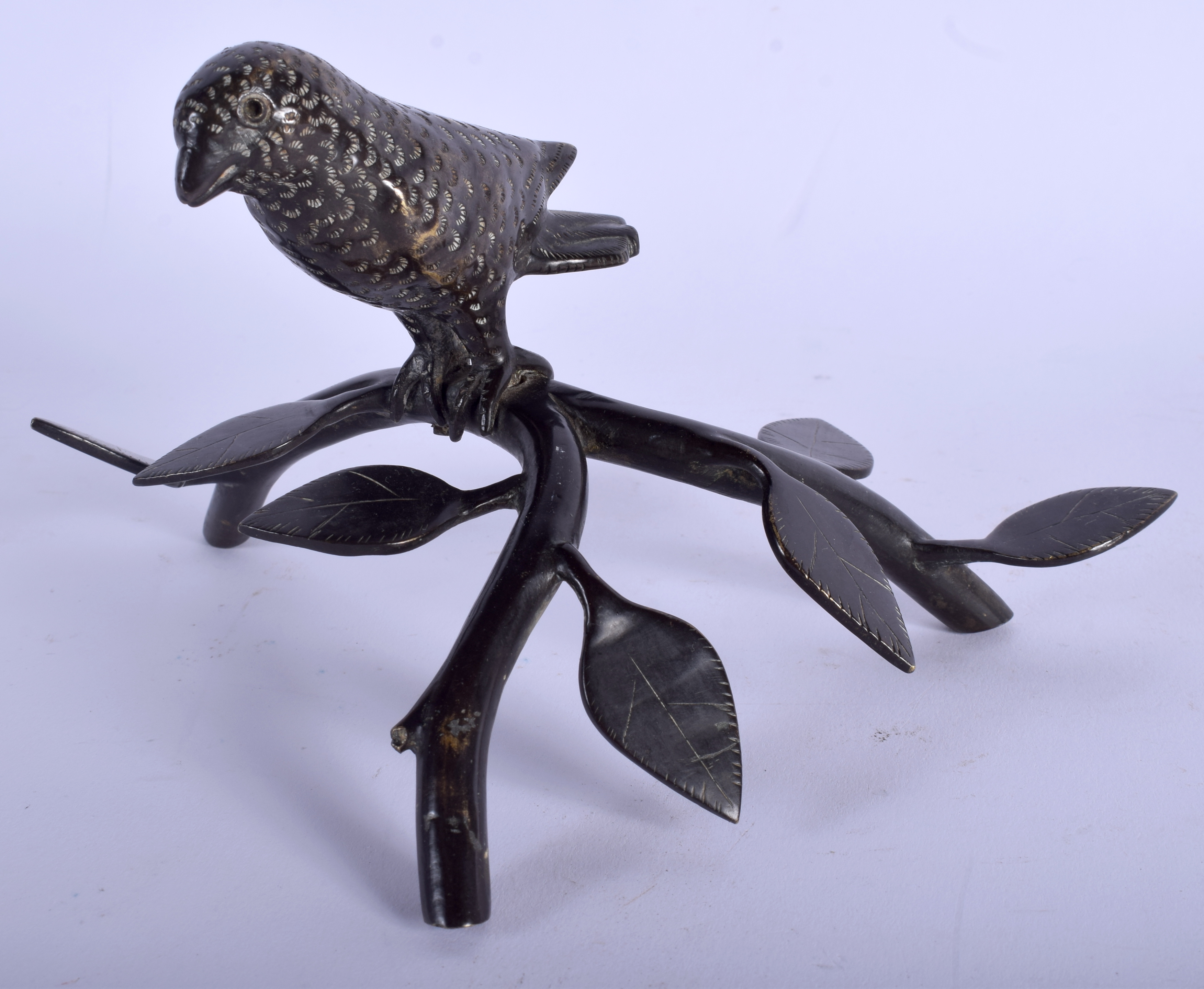 A MIDDLE EASTERN INDIAN BRONZE FIGURE OF A BIRD modelled upon a naturalistic branch. 14 cm x 11 cm.