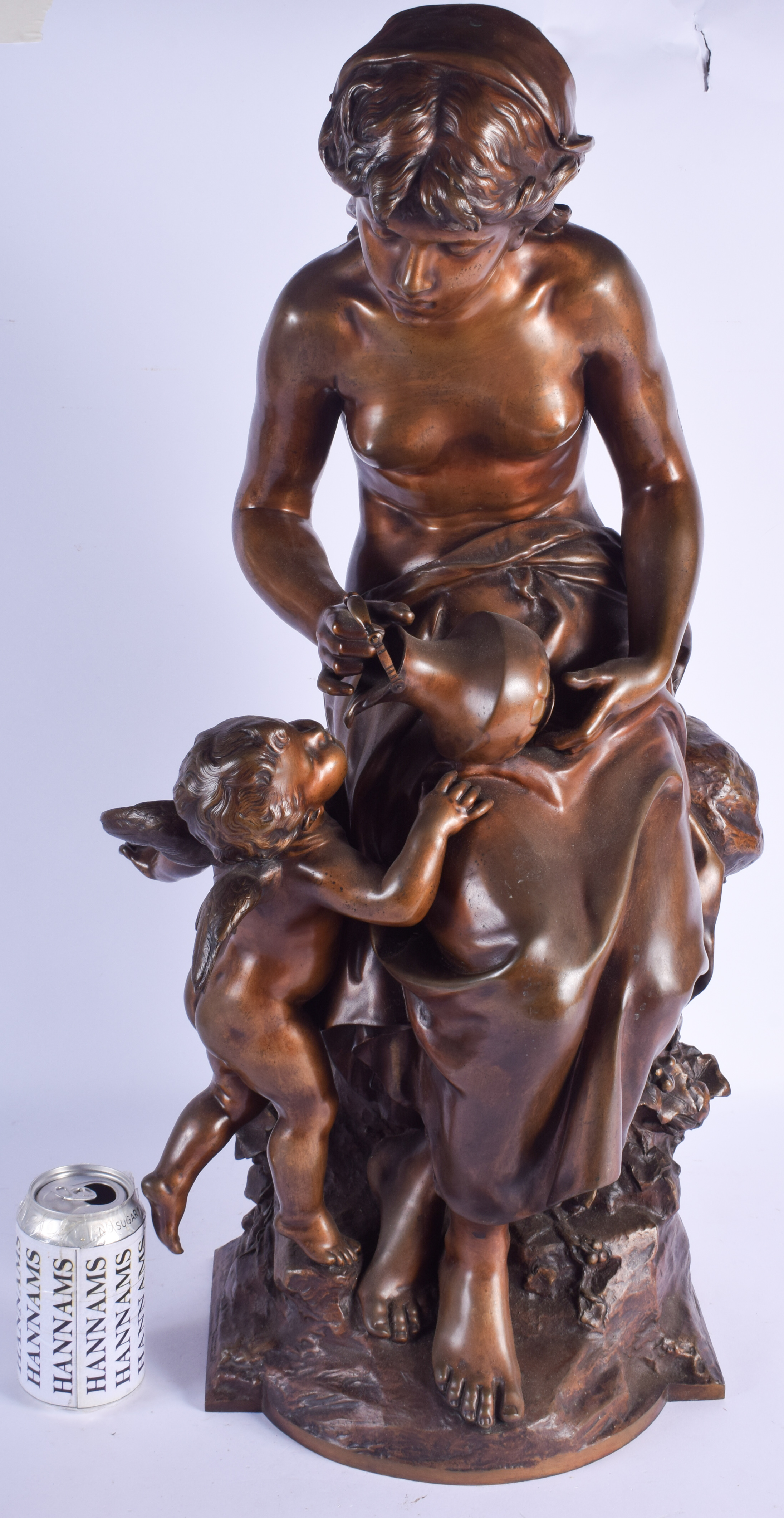 A VERY LARGE 19TH CENTURY FRENCH BRONZE FIGURE OF A FEMALE modelled pouring water into a putti's mo