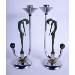 A PAIR OF ART DECO CHROME CANDLESTICKS of figural form. 28 cm high.