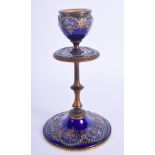 A 19TH CENTURY FRENCH ENAMELLED GILT METAL CANDLESTICK jewelled with turquoise. 15.5 cm high.