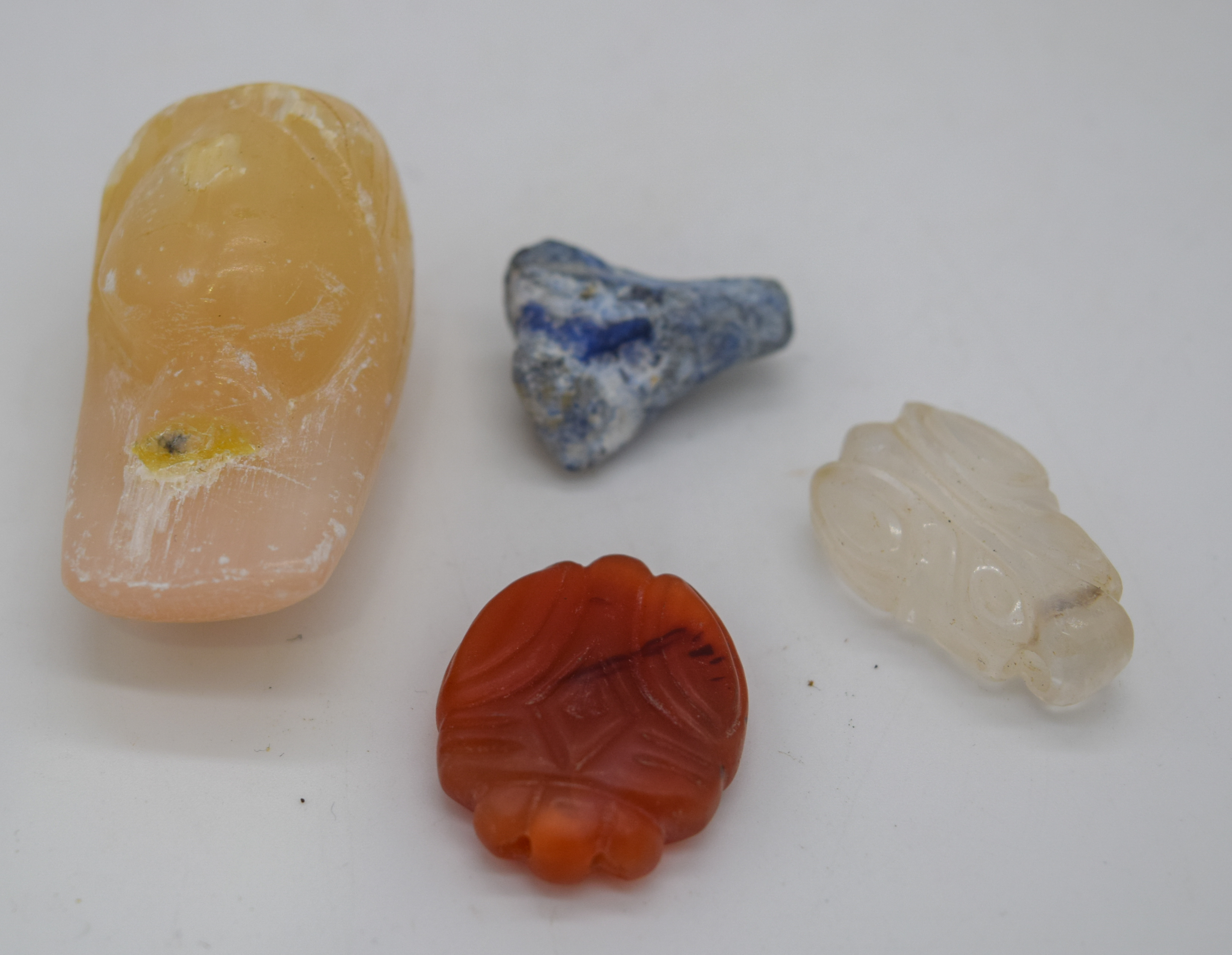 Three small stone pendants and a small carved boulder
