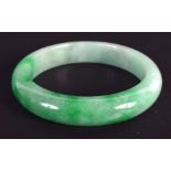 A CHINESE CARVED JADEITE BANGLE 20th Century. 7.25 cm wide.
