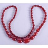 AN ART DECO CHERRY BEAD NECKLACE possibly amber. 44 grams. Largest bead 62 cm long, largest bead 2 c