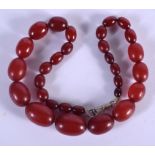 AN ART DECO CHERRY AMBER BAKELITE NECKLACE. 54 grams. 46 cm long, largest bead 2.75 cm x 1.5 cm.