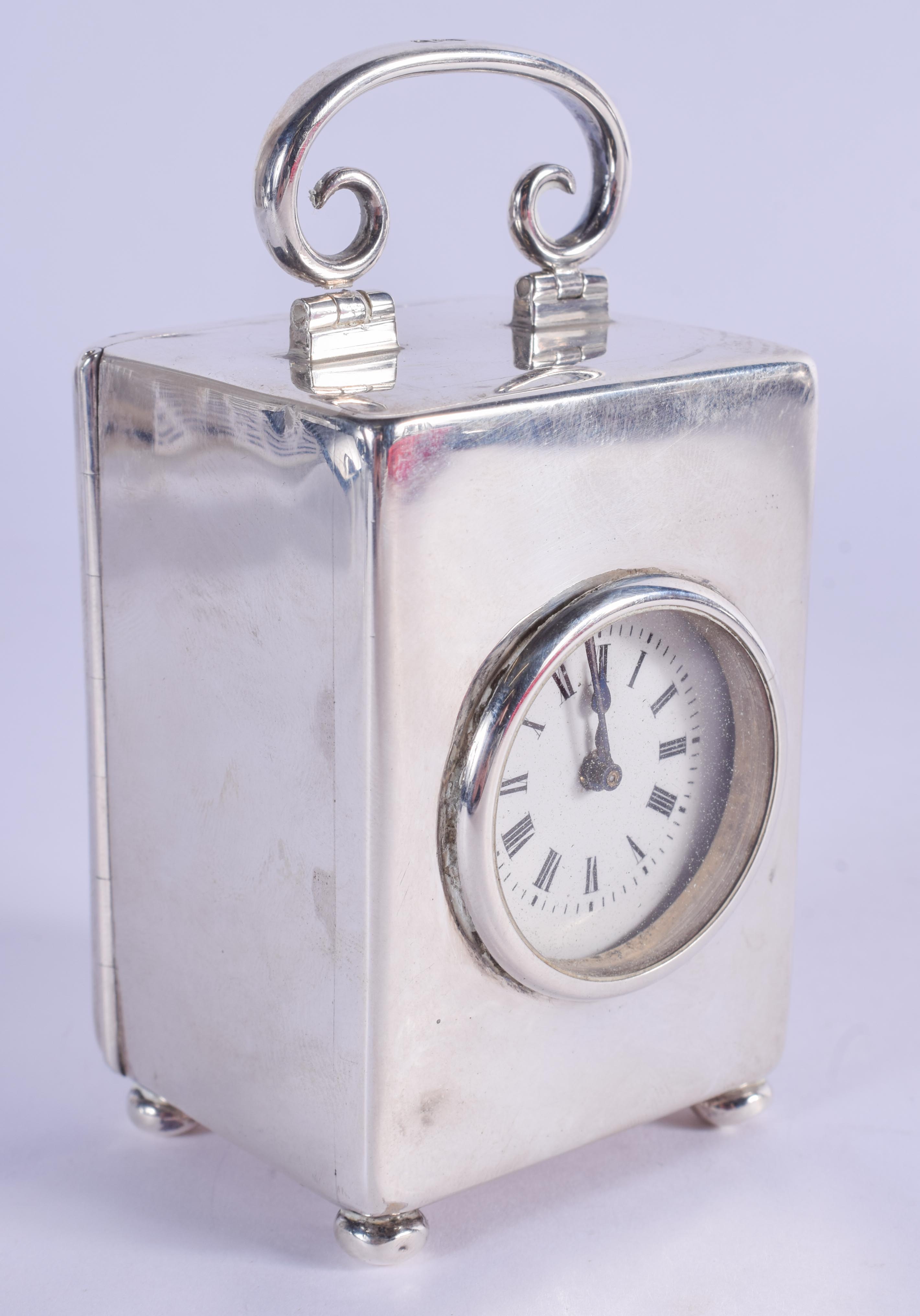 AN EDWARDIAN SILVER TRAVELLING CARRIAGE CLOCK. London 1901. 354 grams. 11 cm high inc handle.