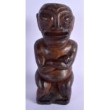 A SOUTH PACIFIC CARVED TRIBAL SEATED FIGURE possibly from Tahiti or Marquesas Islands. 33 cm high.