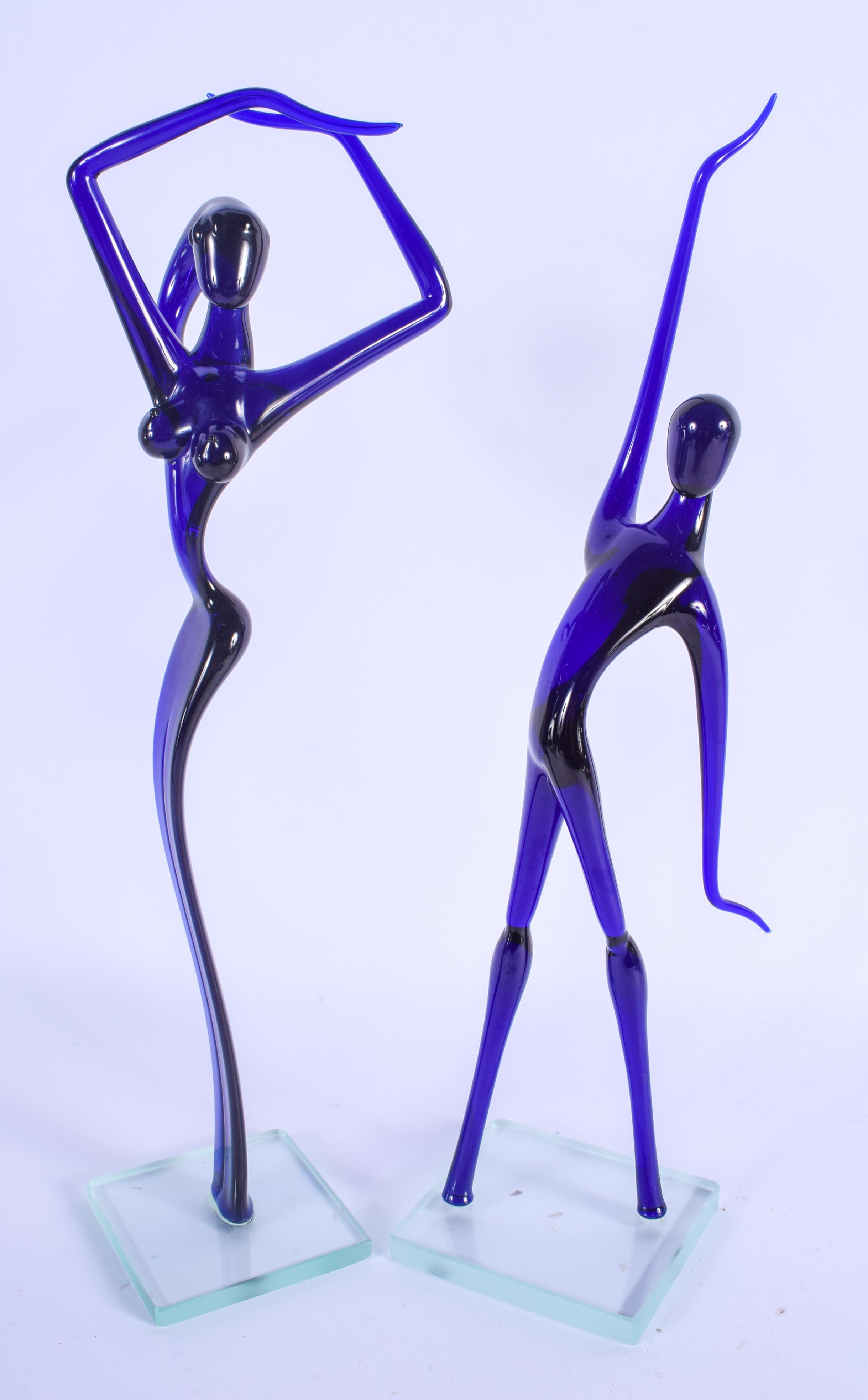 A RETRO PAIR OF EUROPEAN BLUE GLASS FIGURES. 32 cm high.