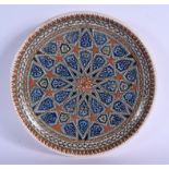 A MIDDLE EASTERN TURKISH KUTAHYA POTTERY DISH painted with star shaped flowers. 30 cm diameter.