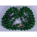 AN 18CT GOLD CHINESE CARVED JADEITE NECKLACE. 104 cm long, each bead 0.7 cm wide.