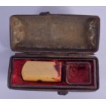 AN EARLY 20TH CENTURY CHINESE CARVED IVORY SEAL within a fitted tin box. Ivory 3 cm high.