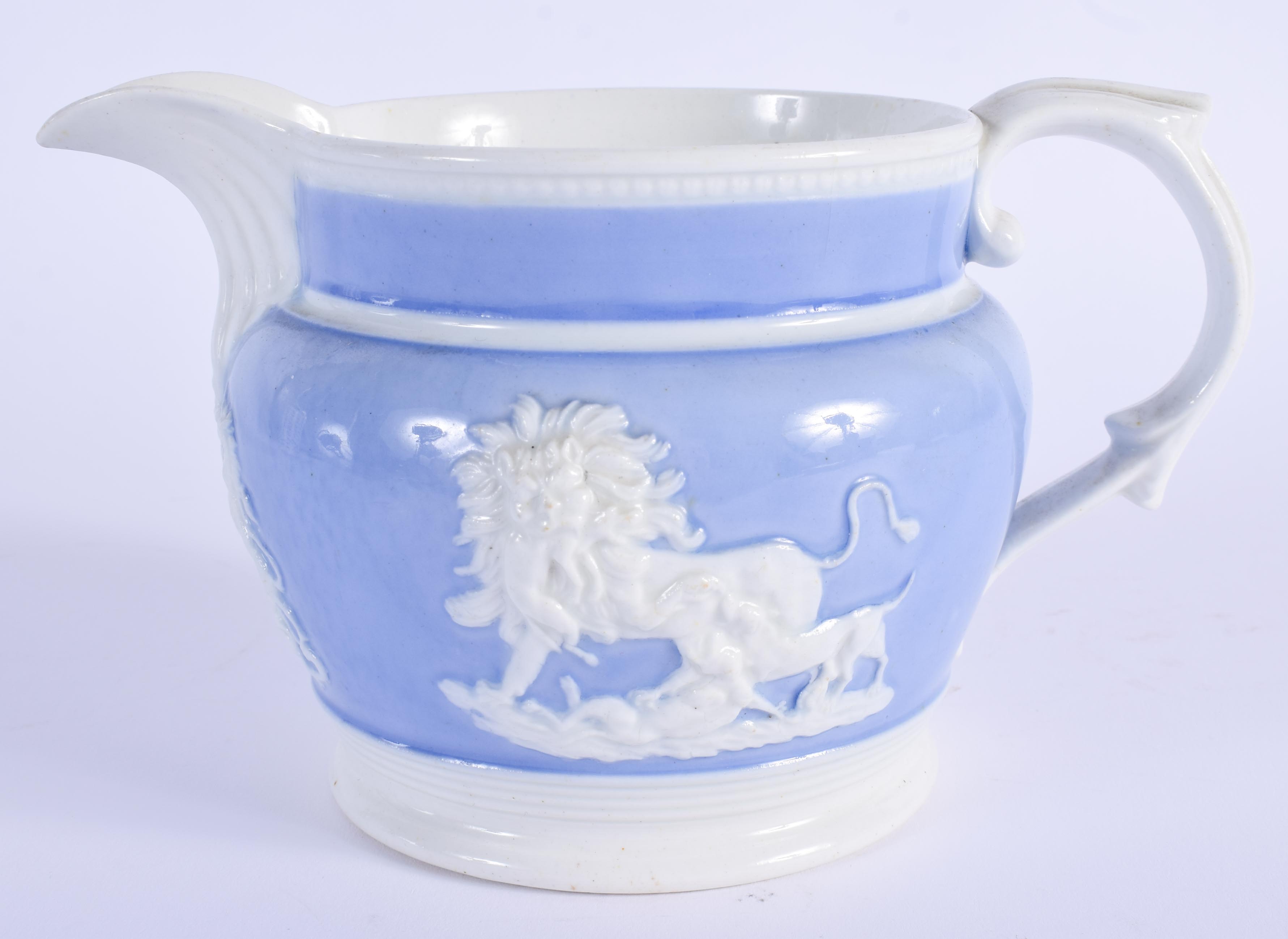 A 19TH CENTURY ENGLISH LAVENDER GLAZED POTTERY JUG decorated with moulded animals. 16 cm wide.