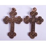 A PAIR OF ANTIQUE YELLOW METAL CRUCIFIXES. 7 grams.