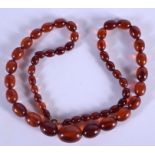 AN EARLY 20TH CENTURY AMBER NECKLACE. 30 grams. 60 cm long, largest bead 2 cm x 1 cm.