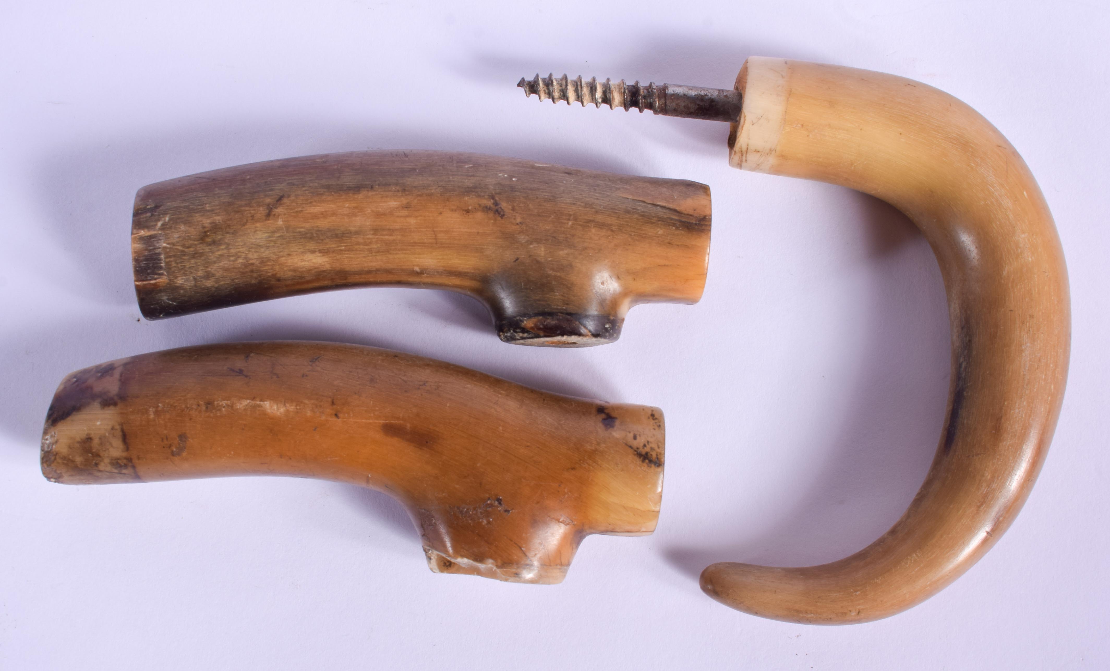 THREE 19TH CENTURY CARVED CONTINENTAL CARVED RHINOCEROS HORN HANDLES. Largest 11 cm wide. (3)