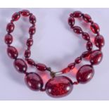 AN ART DECO CHERRY AMBER NECKLACE. 42 grams. 44 cm long, largest bead 3 cm.