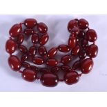 AN ART DECO CHERRY AMBER BAKELITE NECKLACE. 120 grams. 92 cm long, largest bead 3 cm x 2.75 cm.