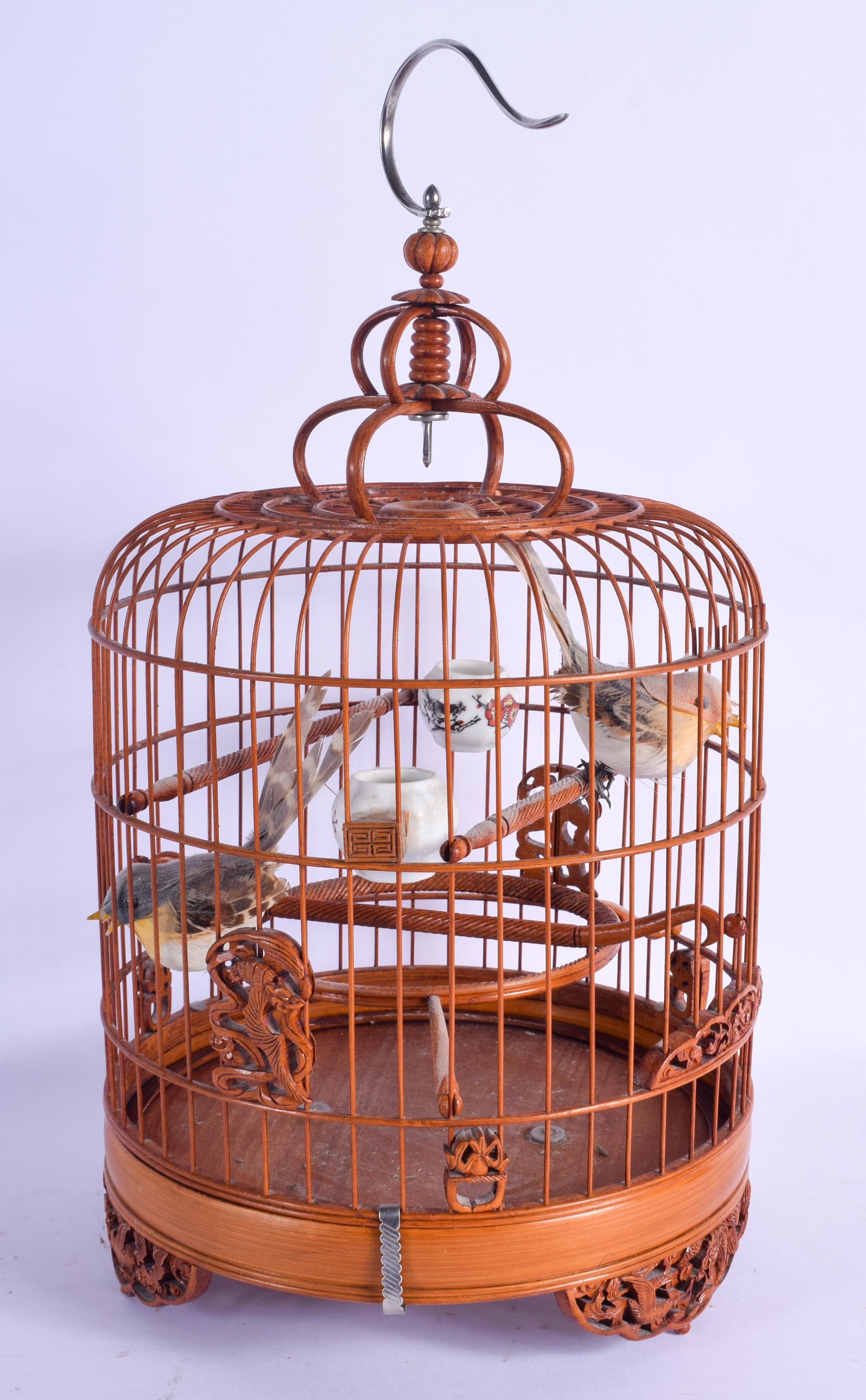 A CHINESE REPUBLICAN PERIOD BAMBOO BIRD CAGE with porcelain feeders. 35 cm x 18 cm.