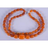 AN EARLY 20TH CENTURY AMBER NECKLACE. 12.8 grams. 46 cm long, largest bead 1.25 cm wide.