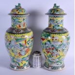 A LARGE PAIR OF 19TH CENTURY CHINESE FAMILLE JAUNE VASES AND COVERS painted with warriors within lan