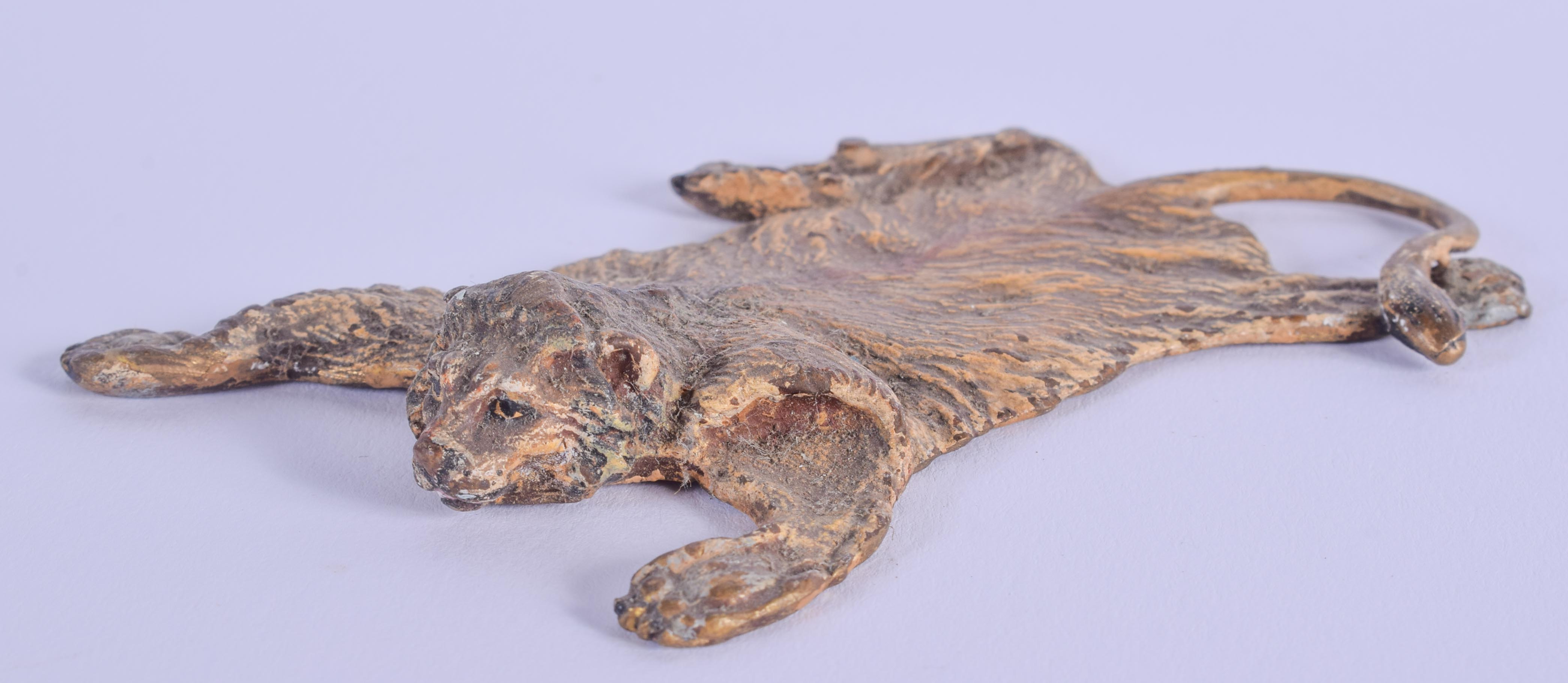 A COLD PAINTED BRONZE LION RUG. 8 cm x 6 cm.