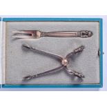 A PAIR OF SILVER GEORG JENSEN SILVER SUGAR TONGS and a matching fork. (2)