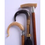 TWO 19TH CENTURY CARVED BUFFALO HORN HANDLED WALKING CANES and a horn handled parasol. Largest 88 cm