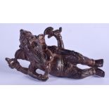 A 19TH CENTURY INDIAN BRONZE FIGURE OF A RECLINING GANESHA modelled in foliate robes. 15 cm x 10 cm.