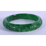 A CHINESE CARVED GREEN JADE BANGLE 20th Century. 7 cm diameter.