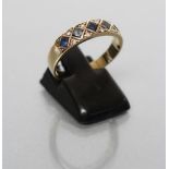 A SAPPHIRE AND DIAMOND HALF HOOP RING set with five square cut sapphires in lozenge panels with