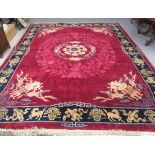 A CHINESE WASHED AND FRINGED CARPET, the raspberry pink field centred by a cream and blue floral
