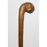 A WALKING STICK, probably late Victorian, the club shaped pommel with an all over pen and ink design