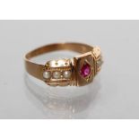 A LATE VICTORIAN 15CT GOLD RING centred by a gypsy set ruby within panelled shoulders each set