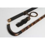 A REGENCY EBONY WALKING CANE, the finely ribbed tapering shaft with fluted metal tip, eyelets with