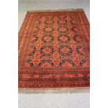 AN AFGHAN CARPET, 20th century, the field with repeating floral gul pattern in navy blue and red and