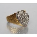 A GENTLEMAN'S DIAMOND SIGNET RING, the raised double heart fascia pave set with numerous stones to a